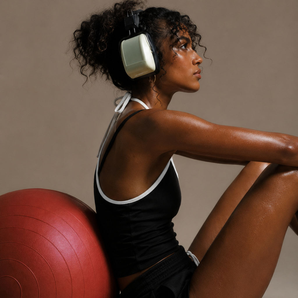 Woman in black athletic wear with a red exercise ball against a neutral background